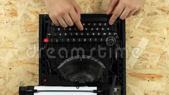盖伊正在一台复古印刷打字机上打字从上面看视频的预览图