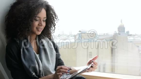 一个微笑的黑发女人在用数码平板电脑工作视频的预览图