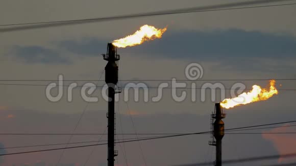 在阴天的衬托下炼油厂有两支燃烧的火炬视频的预览图