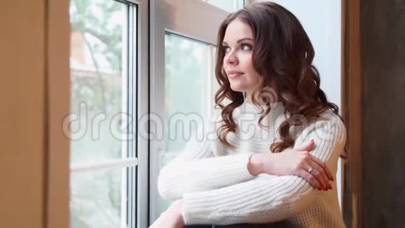 冬天坐在窗边的年轻美女视频的预览图