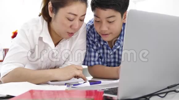 母亲和儿子玩和看智能手机多莉拍摄了快乐的亚洲家庭在家的笑脸视频的预览图