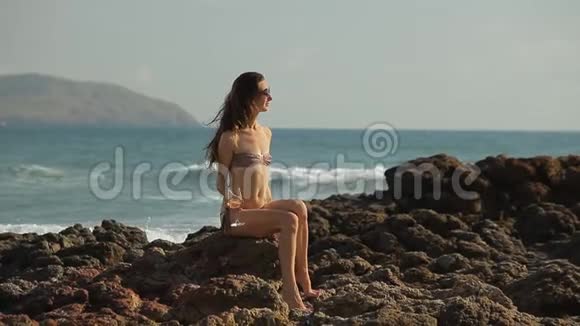 穿着泳衣和太阳镜在海滩上玩得很开心的漂亮年轻女人视频的预览图