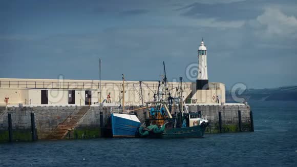 码头和小灯塔旁的渔船视频的预览图