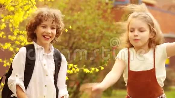 学童兄妹男孩和女孩在一棵盛开的春天树的背景下拥抱日视频的预览图