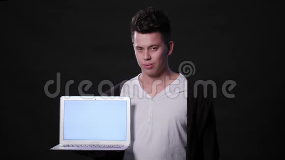一个在黑色背景下拿着笔记本电脑的人视频的预览图