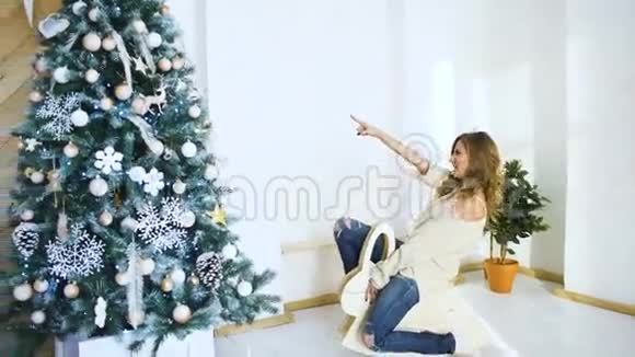 年轻女子在聚会的圣诞树旁尽情欢乐视频的预览图