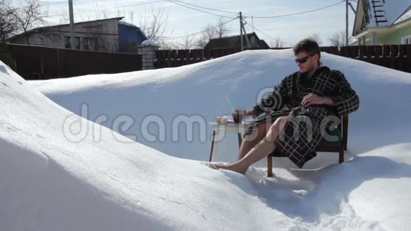 年轻人在雪地上休息喝果汁视频的预览图