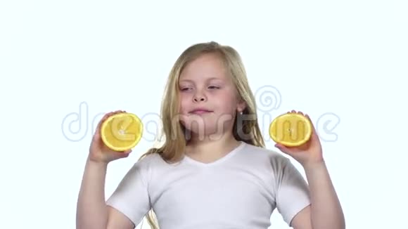 小女孩拿着一个橙色的切片闭上眼睛和曲线白色背景慢动作视频的预览图