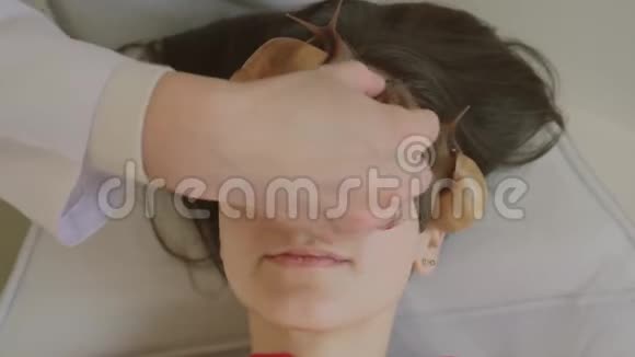 脸上的大蜗牛在水疗中心的年轻女子接受了一个与蜗牛Achatina的面部按摩蜗牛吃掉死皮视频的预览图