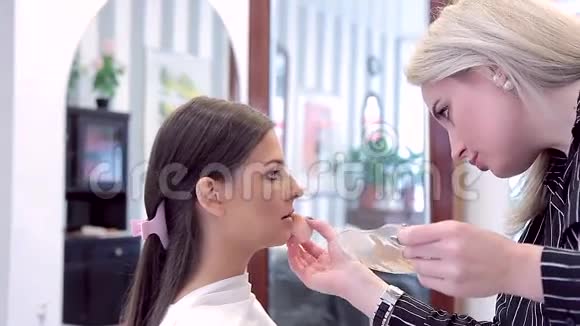 化妆师用奶油粉底做嘴唇模型视频的预览图