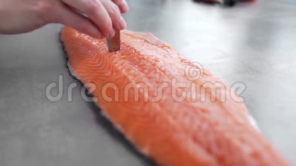 厨师从三文鱼片中取出骨头切鱼配鱼盘饮食健康烹饪在厨房视频的预览图