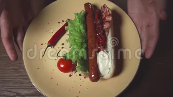 盘子里有美味的热狗快餐餐家常菜烤肠和辣椒酱视频的预览图