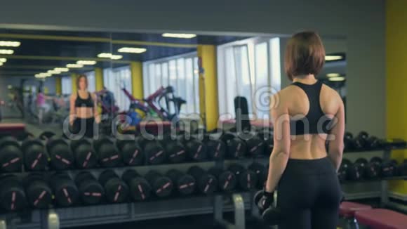 运动爱好者在镜子前举起哑铃发展肌肉视频的预览图