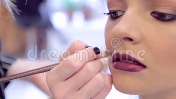 化妆师用粉底矫正模特的嘴唇视频的预览图