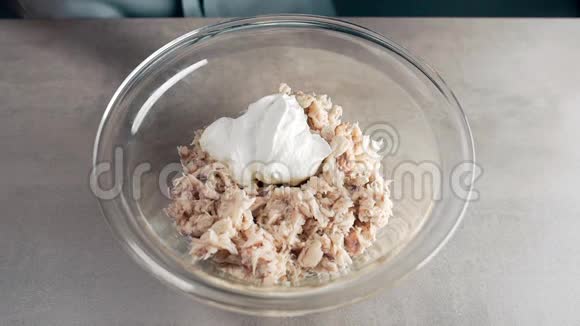 酸的奶油从勺子里慢慢地掉进了饭菜里厨师做鱼碟准备晚餐在视频的预览图