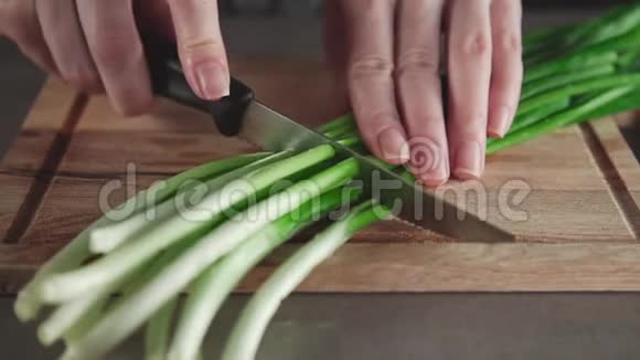女人在厨房的木板上切洋葱自家花园的青菜夏天的维生素有用视频的预览图