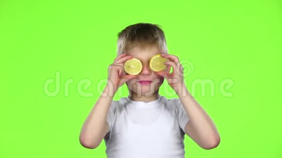 带着柠檬片的孩子舔它们露出鬼脸绿色屏幕慢动作视频的预览图