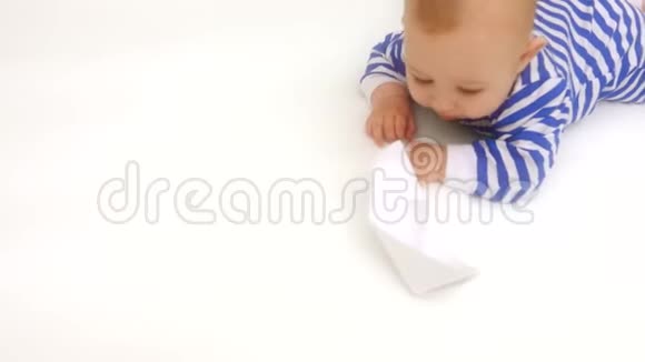 穿着条纹连衣裙的可爱宝宝玩纸船视频的预览图