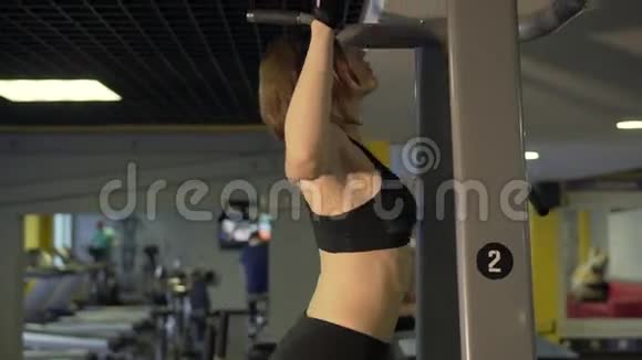 来健身的女人在模拟器上拉起以加强肌肉视频的预览图