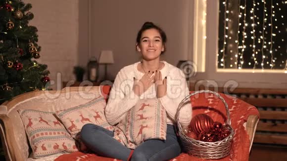女博客坐在家里的沙发上谈论新年和圣诞节视频的预览图