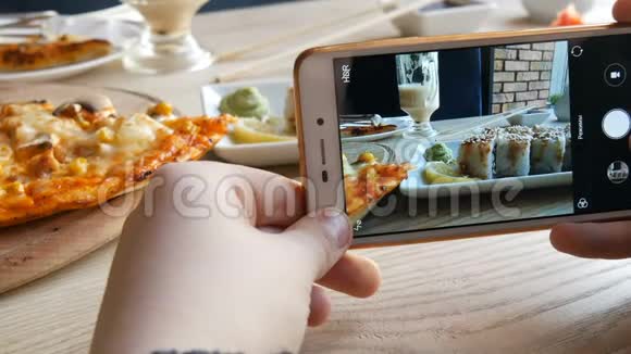 青少年的手在智能手机上制作食物的照片一套日本料理的寿司卷和披萨视频的预览图