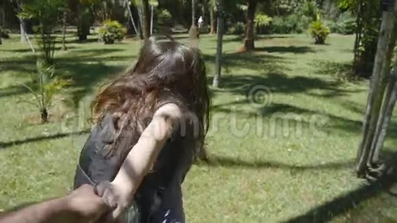 跟着我拍的年轻女人带着背包拉着她的男朋友在丛林里女孩牵着男人的手继续跑视频的预览图