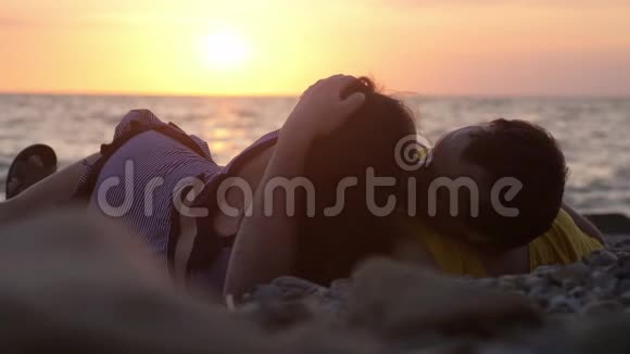 恋爱中的情侣浪漫地躺在阳光下互相看着对方慢慢地亲吻着享受日落3840x2160视频的预览图