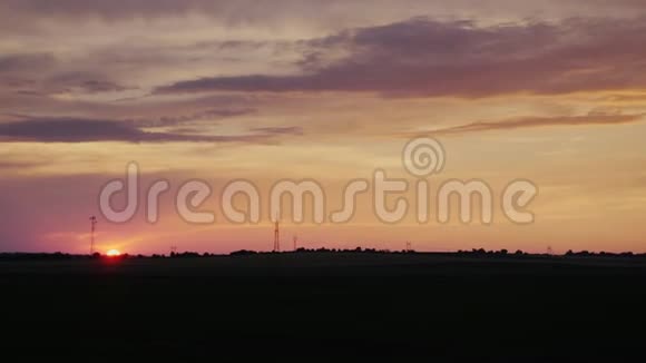 夕阳在农村的田野上的圆盘从一辆移动汽车的窗户看视频的预览图