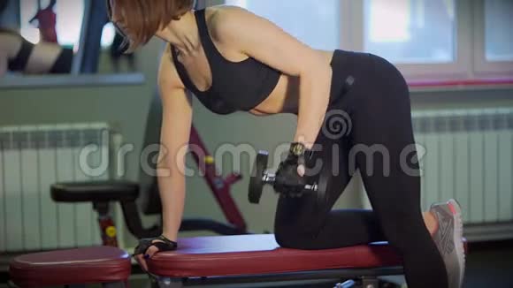 体育俱乐部的健身教练用哑铃摇动背部肌肉视频的预览图