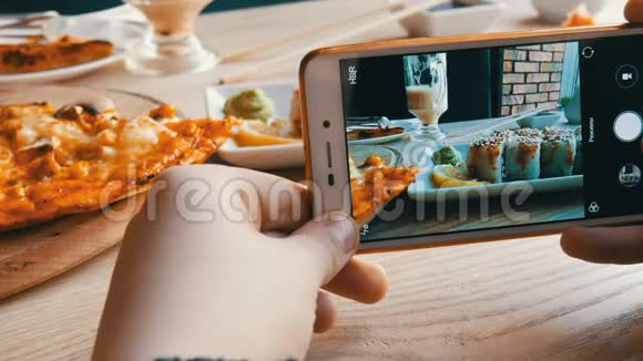 青少年的手在智能手机上制作食物的照片一套日本料理的寿司卷和披萨视频的预览图