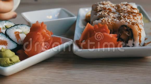 餐厅桌上的盘子上摆着日本料理制作的美味的黑白寿司卷视频的预览图