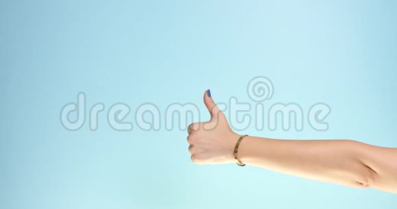 女人的大拇指放在蓝色背景上视频的预览图