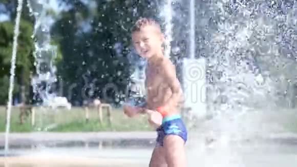 可爱的孩子一个七岁的男孩在炎热的夏天在喷泉里洗澡在外面玩水视频的预览图