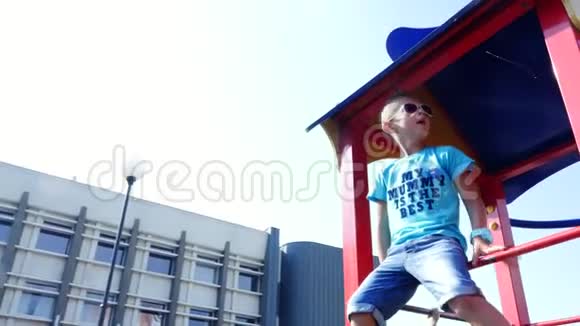 可爱的七岁男孩在夏天的户外操场上玩得很开心慢动作快乐活跃的童年视频的预览图