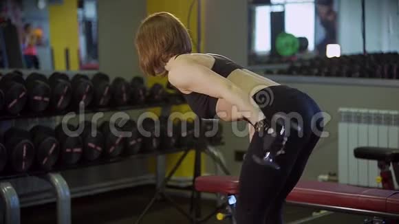 运动员的女孩站在弯曲的位置并泵动前臂的肌肉视频的预览图