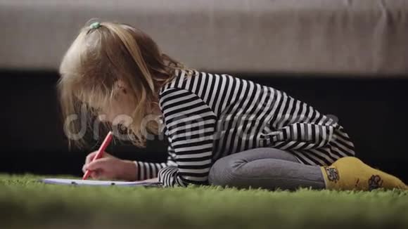 可爱的小女孩在托儿所里用铅笔画画小公主正在用红笔画图案金发美女视频的预览图