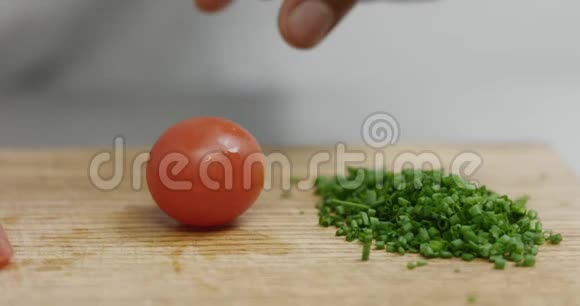 切樱桃西红柿旁边一堆切碎的韭菜视频的预览图