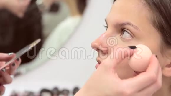 化妆师在模特脸上涂上遮瑕膏视频的预览图