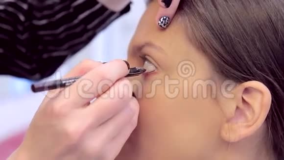 化妆师在模特的脸上涂上眼线视频的预览图