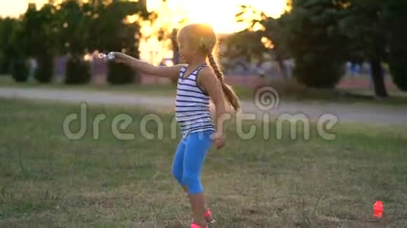 日落时分小女孩在公园里玩泡泡视频的预览图
