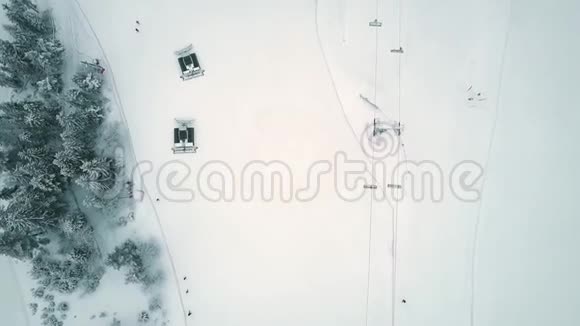 冬季滑雪胜地斜坡上雪猫或雪修复者的高空俯视图视频的预览图