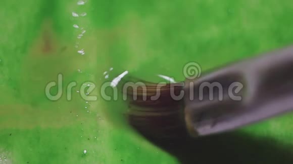 湿纸罐上的绿色水彩颜料视频的预览图