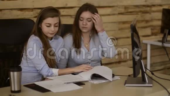 年轻女孩在阁楼上工作讨论一个项目讨论公司新闻视频的预览图