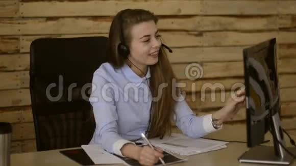 小女孩喜欢在办公室里用触摸屏在电脑前工作呼叫中心代理视频的预览图