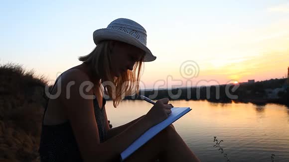 在日落时分在河边有一个笔记本的创意个性视频的预览图