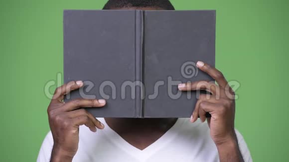 年轻的非洲男人用书遮住脸视频的预览图