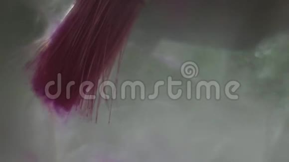 在液体中漂浮的漂亮的紫色油漆形状视频的预览图