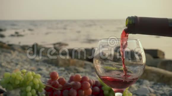 慢的酒倒在海边的玻璃杯里视频的预览图