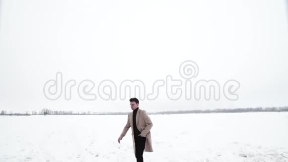 年轻的富翁走在雪地上乘着跑车视频的预览图
