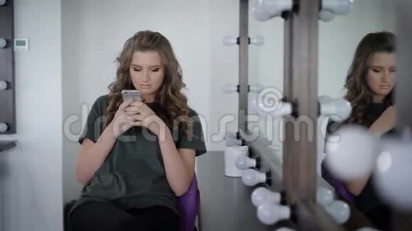 美发店的女顾客在做完发型和使用后坐在镜子附近用灯照镜子视频的预览图
